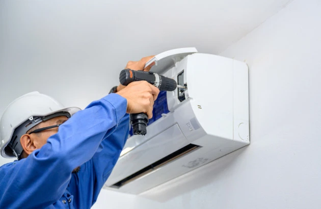 Técnico utilizando ferramenta na instalação de um ar-condicionado split